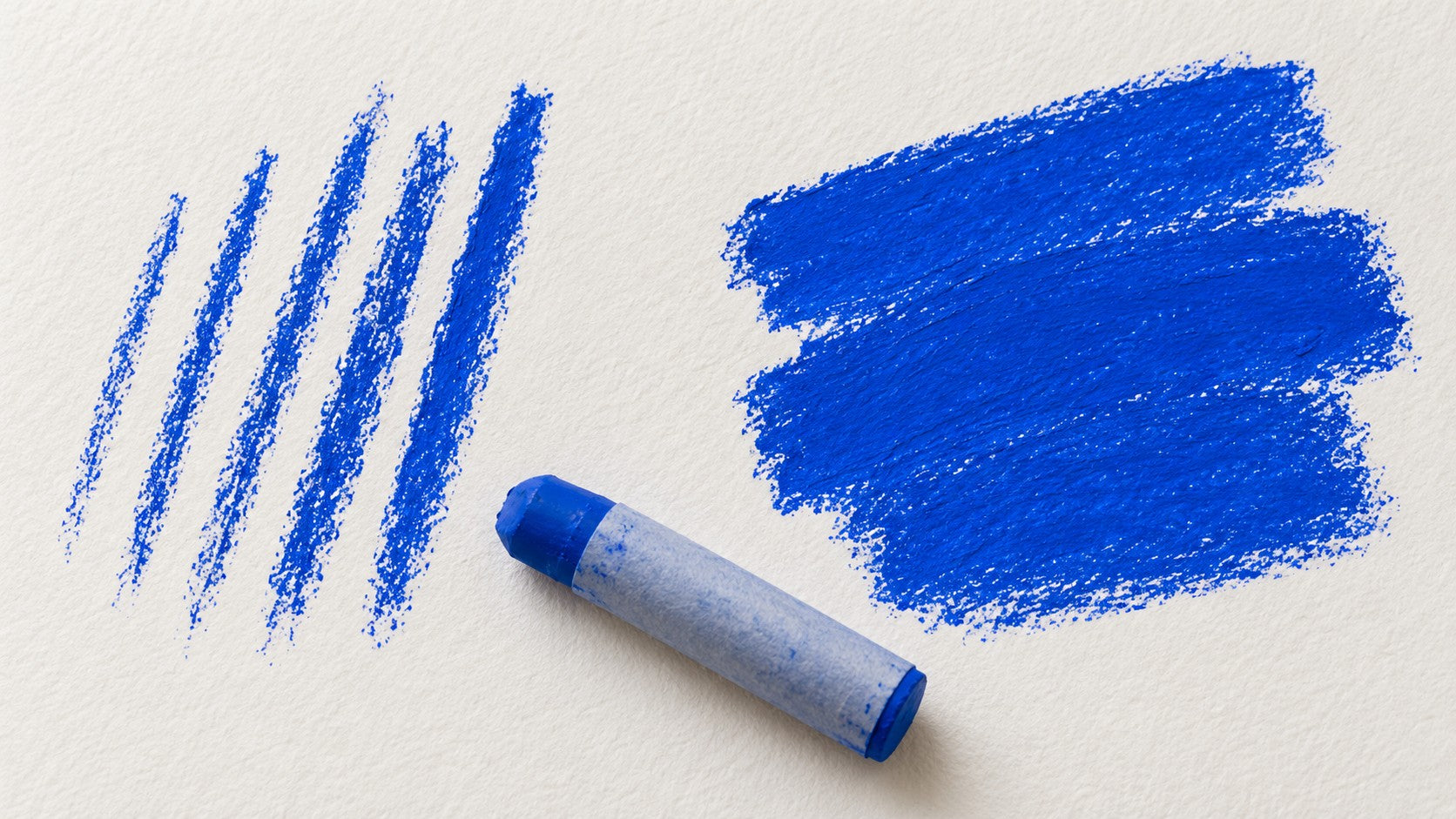 Illustration comparing narrow blue oil pastel lines with broad overlapping blue side strokes on the same paper